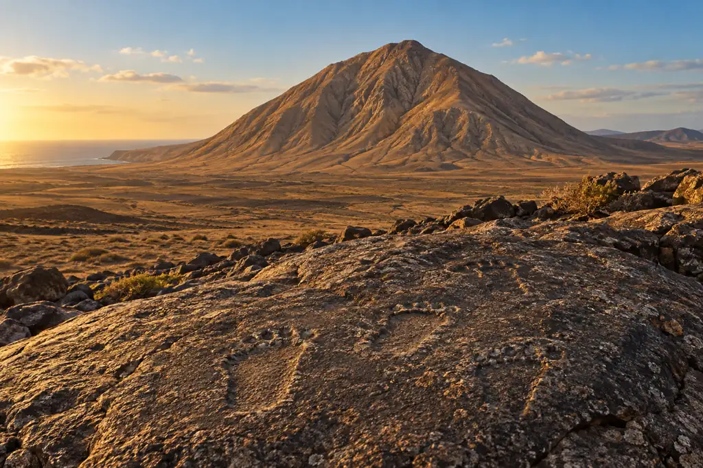 Recreación visual genérica de Tindaya y motivos podomorfos sobre la piedra